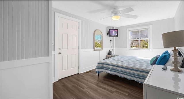 bedroom with ceiling fan, dark hardwood / wood-style floors, and a textured ceiling