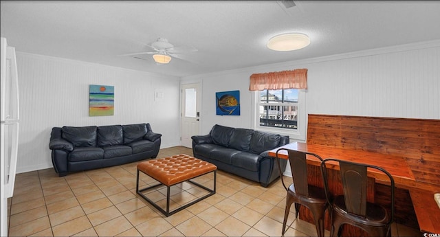 tiled living room with a textured ceiling, ornamental molding, and ceiling fan