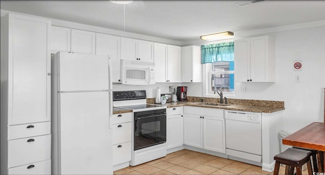 kitchen featuring sink, white appliances, light tile patterned floors, and white cabinets