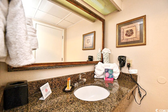 bathroom featuring a drop ceiling and sink