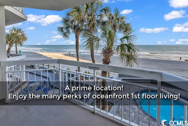 balcony with a water view and a view of the beach