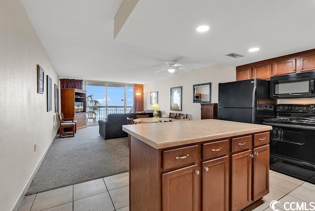 kitchen with a kitchen island, ceiling fan, floor to ceiling windows, black appliances, and light carpet