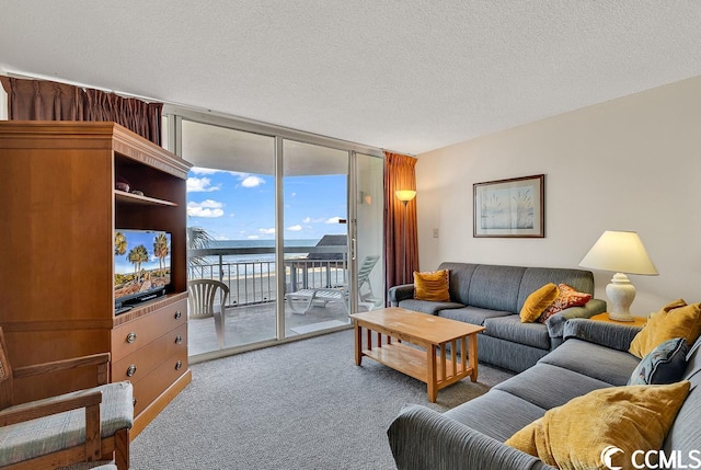 carpeted living room with a water view, expansive windows, and a textured ceiling