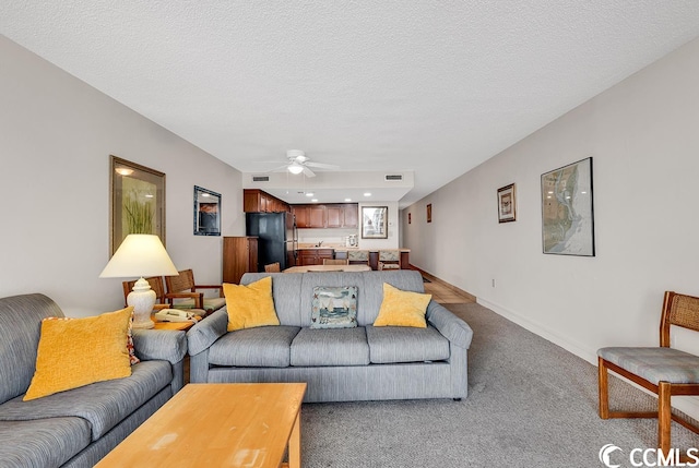 living room with carpet floors, a textured ceiling, and ceiling fan