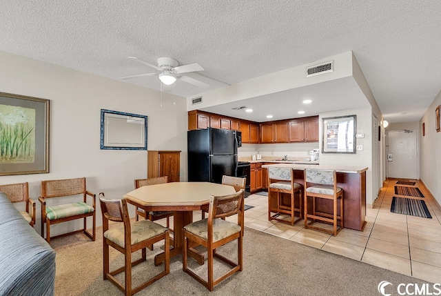 dining space featuring light tile flooring, ceiling fan, a textured ceiling, and sink