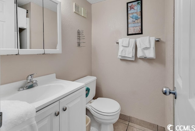 bathroom featuring a textured ceiling, tile floors, oversized vanity, and toilet