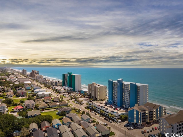 aerial view at dusk featuring a water view