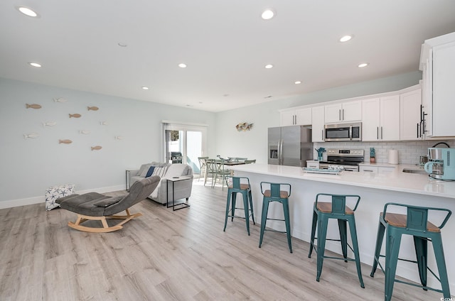 503 30th Ave N, Myrtle Beach, SC 29577 - kitchen featuring stainless steel appliances, a breakfast bar area, light wood-type flooring, a peninsula, and recessed lighting