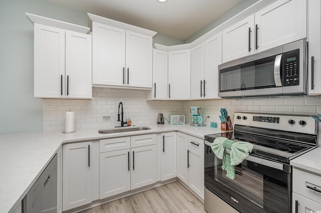503 30th Ave N, Myrtle Beach, SC 29577 - kitchen featuring appliances with stainless steel finishes, a sink, white cabinets, and backsplash