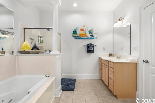 bathroom featuring decorative columns, vanity, tile floors, and a bathtub