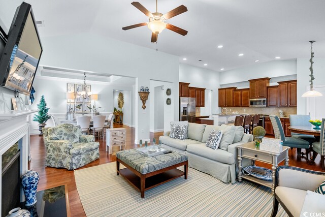 living room with light hardwood / wood-style floors and ceiling fan with notable chandelier