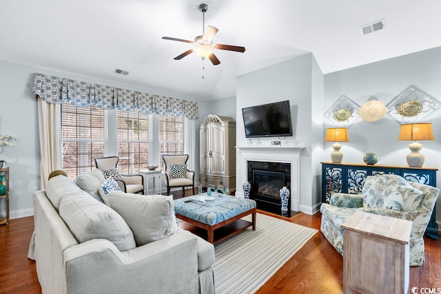 living room with ceiling fan, dark wood-type flooring, and vaulted ceiling