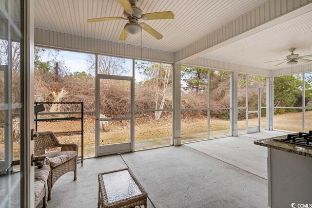 unfurnished sunroom with ceiling fan