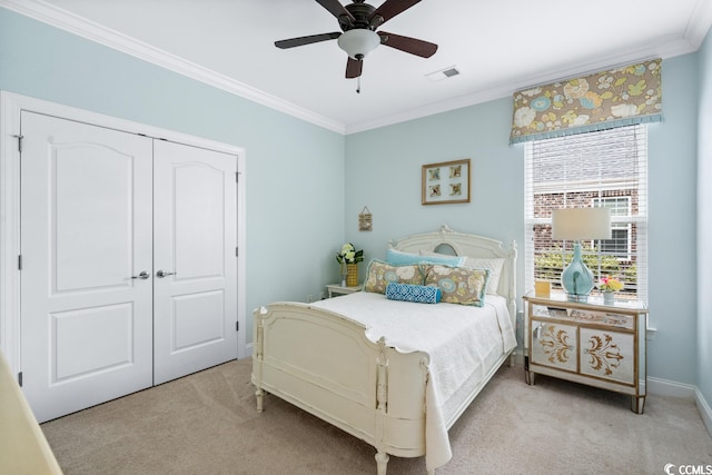 bedroom featuring a closet, crown molding, light colored carpet, and ceiling fan