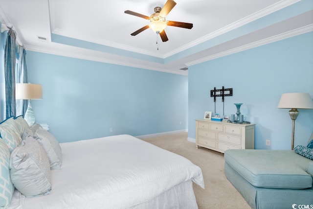 carpeted bedroom with crown molding, a tray ceiling, and ceiling fan