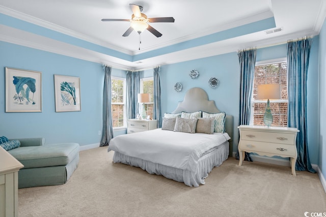 carpeted bedroom featuring ceiling fan, ornamental molding, and a tray ceiling