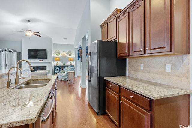 kitchen with light wood-type flooring, tasteful backsplash, ceiling fan, stainless steel appliances, and sink