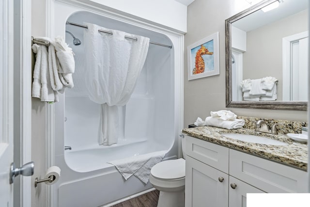 full bathroom featuring  shower combination, toilet, vanity with extensive cabinet space, and hardwood / wood-style floors