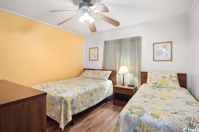 bedroom featuring ceiling fan, crown molding, and hardwood / wood-style flooring