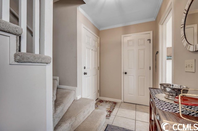 foyer with ornamental molding and light tile floors