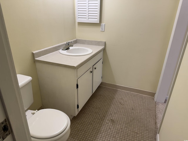 half bathroom with tile patterned floors, toilet, and vanity