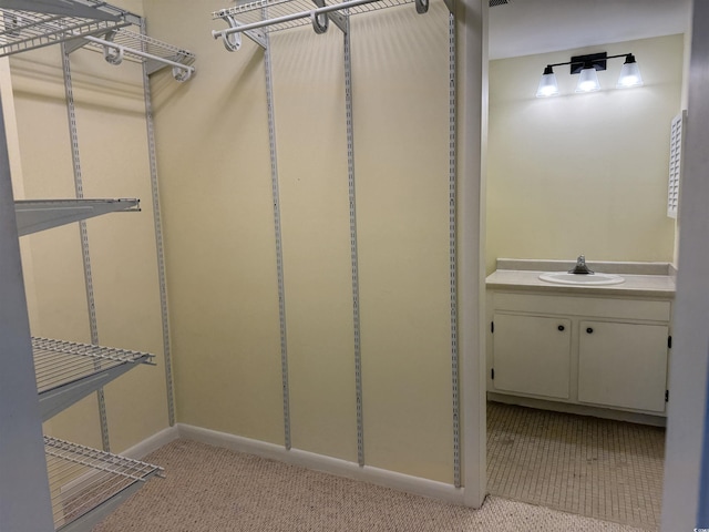 spacious closet featuring a sink and light carpet