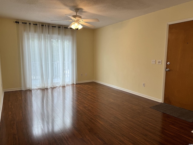 unfurnished room with baseboards, a ceiling fan, a textured ceiling, and dark wood-type flooring