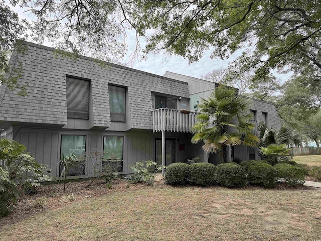 back of property featuring mansard roof, a balcony, and a shingled roof