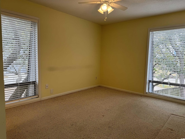 empty room with a ceiling fan, baseboards, and carpet floors