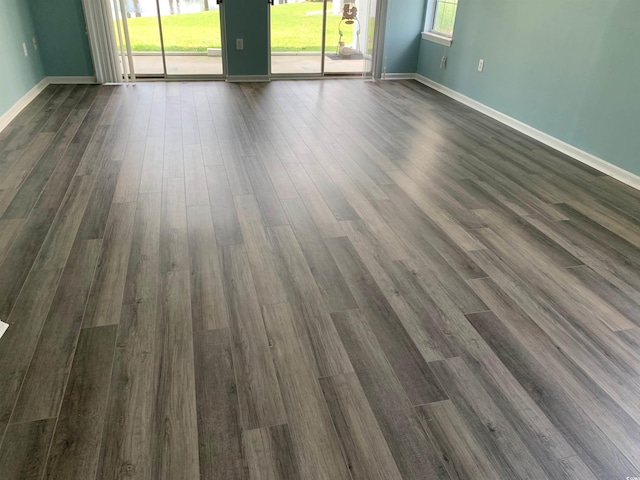 5020 Windsor Green Way Unit 103, Myrtle Beach, SC 29579 - empty room with healthy amount of natural light and dark wood finished floors