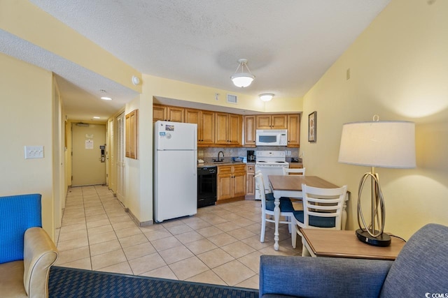 kitchen with a textured ceiling, tasteful backsplash, white appliances, and light tile flooring