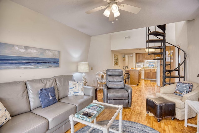 living room featuring ceiling fan and light hardwood / wood-style flooring