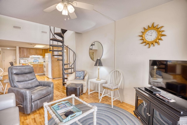 living room featuring ceiling fan and light wood-type flooring