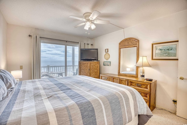 bedroom with ceiling fan, access to outside, light colored carpet, and a textured ceiling