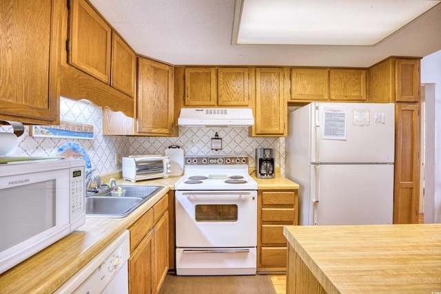 kitchen featuring tasteful backsplash, white appliances, light wood-type flooring, and sink