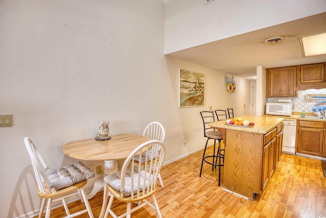 dining space with light hardwood / wood-style flooring and sink