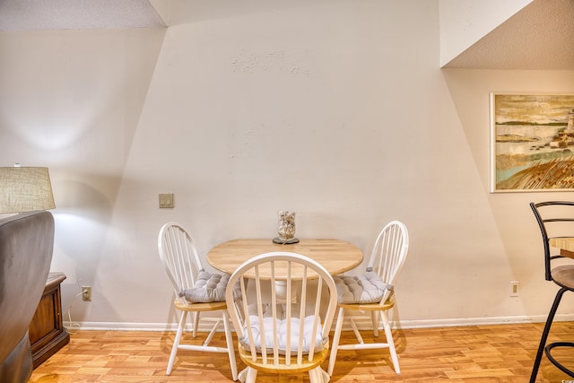 dining room featuring a textured ceiling and light hardwood / wood-style flooring