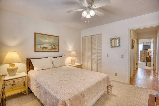 bedroom featuring a closet, light carpet, and ceiling fan