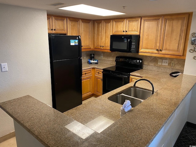 kitchen with backsplash, sink, black appliances, and kitchen peninsula