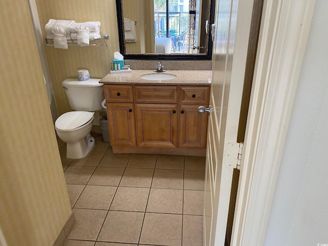 bathroom featuring toilet, tile flooring, and vanity