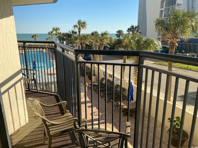 balcony with a water view and a community pool