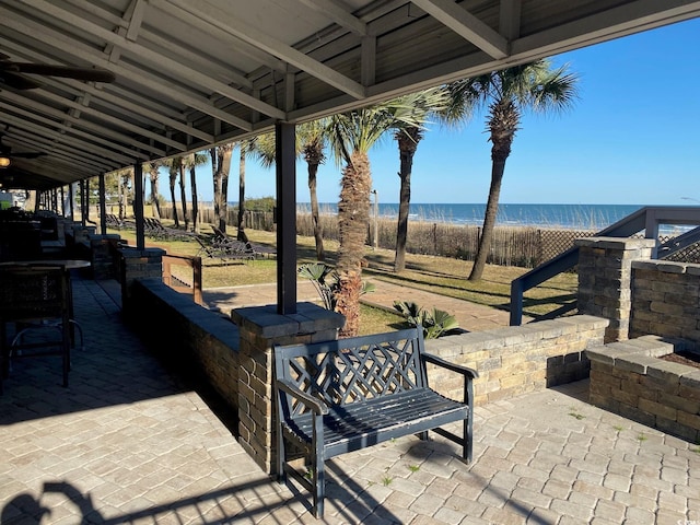 view of terrace with a water view and ceiling fan