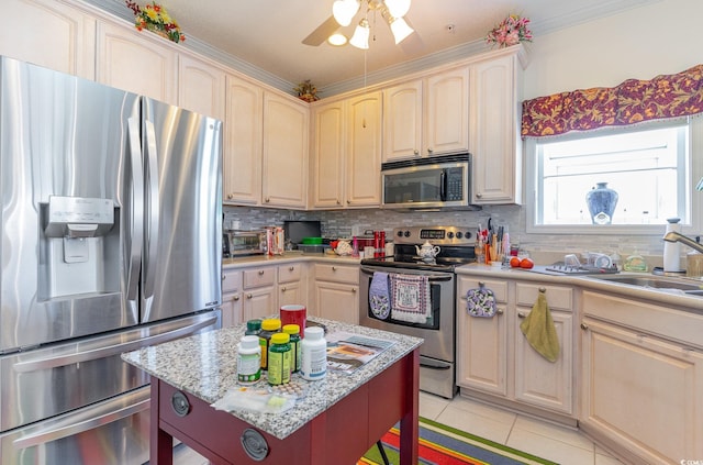 kitchen featuring stainless steel appliances, light tile flooring, ceiling fan, a breakfast bar area, and backsplash