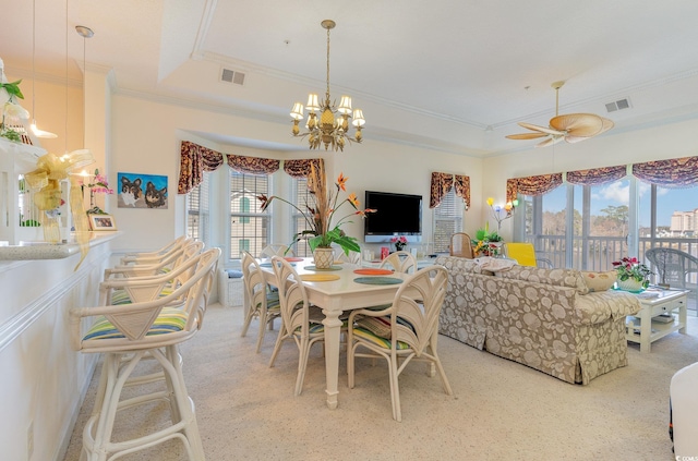 dining area with a raised ceiling and ceiling fan with notable chandelier