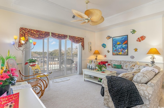 carpeted living room featuring an inviting chandelier, a raised ceiling, and ornamental molding