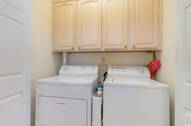 washroom with cabinets and washing machine and clothes dryer