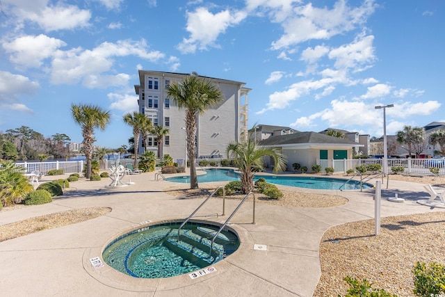 view of swimming pool featuring a hot tub and a patio area