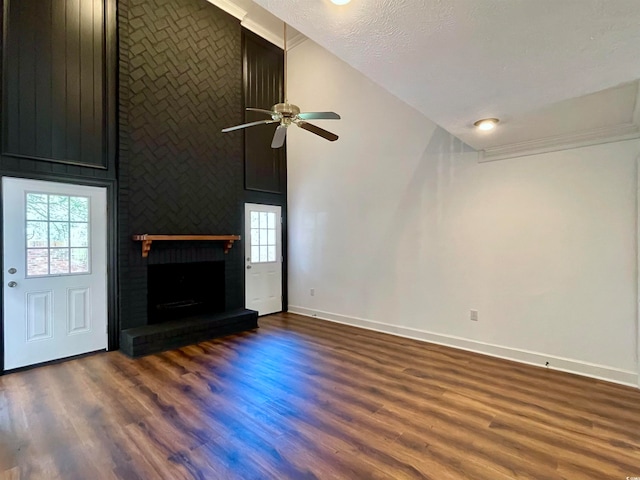 unfurnished living room featuring a fireplace, high vaulted ceiling, dark wood-type flooring, and ceiling fan