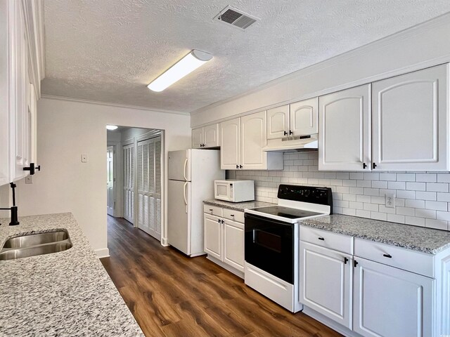 kitchen with white cabinets, white appliances, dark hardwood / wood-style floors, and light stone counters