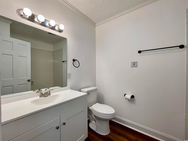 bathroom with crown molding, toilet, hardwood / wood-style floors, a textured ceiling, and large vanity